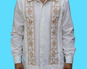 May include: A long-sleeved white button-down shirt featuring two vertical panels of intricate gold floral embroidery flanking the central button placket. The shirt has a classic collar, long sleeves with cuffs, and a straight hemline finish.