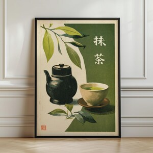 Könnte beinhalten: Ein gerahmter Wandkunstdruck mit einer dunklen Teekanne und einer hellen Schale mit grünem Matcha-Tee. Die Komposition umfasst grüne Teeblätter, einen cremefarbenen Hintergrund, ein dunkelgrünes Feld und die japanischen Schriftzeichen für Matcha.