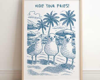 May include: A framed art print featuring three cartoon seagulls on a beach, with palm trees and umbrellas in the background. The text "HIDE YOUR FRIES!" is at the top. The artwork is in shades of blue and white.