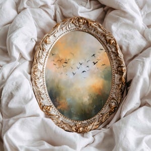 Puede incluir: Un marco de fotos ovalado con un acabado dorado ornamentado y desgastado que contiene una pintura de una bandada de pequeños pájaros negros volando a través de un cielo brumoso y atmosférico lleno de tonos mezclados de naranja, amarillo y verde.