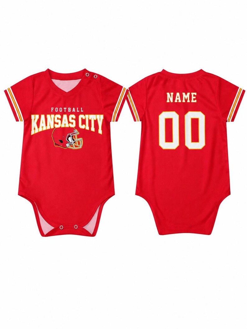 May include: A red short-sleeved baby bodysuit featuring the text KANSAS CITY FOOTBALL and a helmet graphic on the front. The back displays the word NAME above the number 00 in white with yellow outlines. The sleeves have yellow and white stripes.