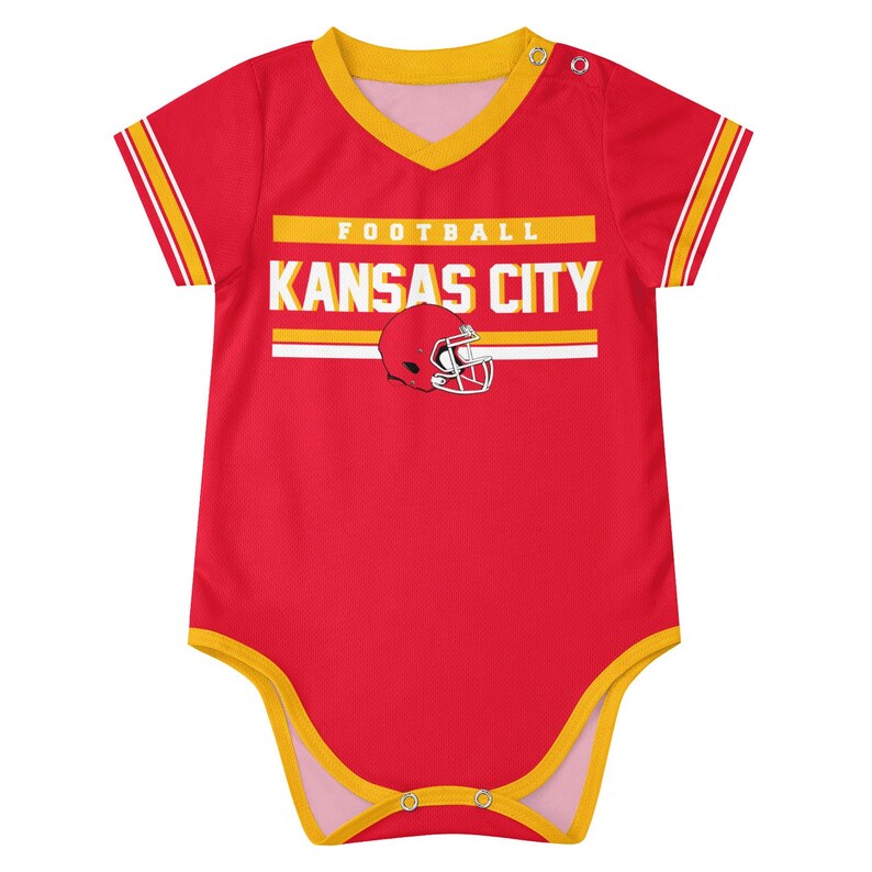 Puede incluir: Un body de beb&eacute; rojo de manga corta con ribetes amarillos en el cuello, las mangas y las aberturas de las piernas. El frente presenta el texto FOOTBALL KANSAS CITY en blanco y amarillo, junto a un gr&aacute;fico de un casco de f&uacute;tbol rojo.