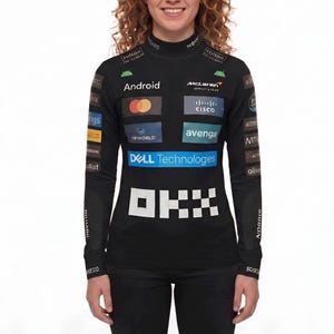 May include: A black long-sleeve mock neck shirt featuring various sponsor logos including Android, McLaren, Cisco, Dell Technologies, and OKX. The shirt has a fitted design with multiple white and colored brand graphics printed across the chest and sleeves.