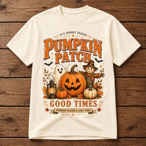 Peut inclure: Un t-shirt couleur crème avec une impression graphique portant le texte IT'S SPOOKY SEASON, PUMPKIN PATCH, GOOD TIMES et PUMPKIN SEASON & COZY VIBES. Le motif inclut une citrouille d'Halloween, un fantôme, un épouvantail et une lanterne.