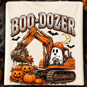 Puede incluir: Una camiseta color crema con un gr&aacute;fico de una excavadora naranja operada por un fantasma blanco con casco naranja. El texto BOO-DOZER aparece arriba en naranja y gris. Debajo, la excavadora recoge calabazas entre hojas de oto&ntilde;o.