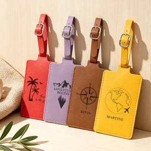 Puede incluir: Cuatro etiquetas de equipaje de cuero en rojo, morado, marrón y amarillo. Cada etiqueta tiene una correa con hebilla y presenta un diseño único: palmeras, montañas, una brújula y un mapa del mundo con un avión. El texto incluye "Adventure Begins" y nombres.