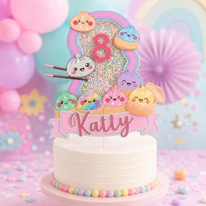 May include: A cake topper featuring a shaker-style number 8 filled with colorful beads, surrounded by several cute, glittery, cartoon-style dumpling characters in bamboo steamers. A pink banner at the bottom displays the name Katty in script.