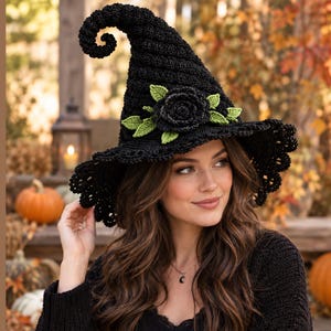 Può includere: Un cappello da strega all'uncinetto nero con una punta alta e ricurva e una tesa larga con bordo smerlato. Il cappello è decorato con una grande rosa centrale all'uncinetto nera circondata da diverse piccole foglie all'uncinetto verde chiaro.