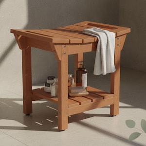 May include: A light brown wooden shower bench with a curved seat, a lower storage shelf, and four sturdy legs. A white towel is draped over the seat, and several small bottles and a bar of soap are arranged on the lower shelf.