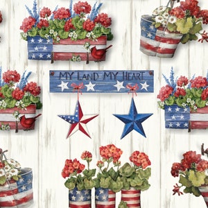May include: A white wood background with red, white, and blue patriotic themed decorations.  There are flower pots with red geraniums and white flowers, a sign that says "My Land My Heart", and stars hanging from the sign.