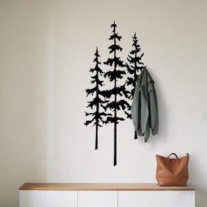 Pode incluir: Cena interior minimalista com uma parede branca adornada com uma silhueta de árvore preta. Um armário de madeira e branco, uma bolsa tote de couro marrom e um casaco cinza completam a decoração. Uma etiqueta indica uma altura de 150 cm.