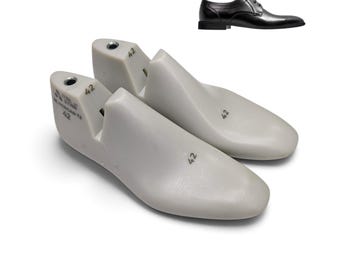 May include: A pair of light gray plastic shoe lasts for size 42 footwear, featuring a sleek, pointed-toe shape. The lasts are marked with the text ITAL STAR, 42, and MORGAN T2. A small inset image shows a black leather dress shoe for reference.