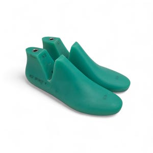 Könnte beinhalten: Zwei teal-farbene Schuhleisten, ein Werkzeug in der Schuhherstellung. Die Leisten sind aus massivem Material und fußförmig. Der Text "RCZ SPIRIT V" ist auf einer Leiste zu sehen. Die Zahl "43" ist auf beiden gestempelt.