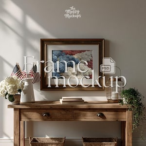 May include: A framed artwork with a brown wooden frame, featuring a colorful abstract design in red, white, and blue. The frame is displayed on a wooden console table, decorated with American flags, flowers, and a decorative lantern. The text "Frame mockup" is overlaid on the image.