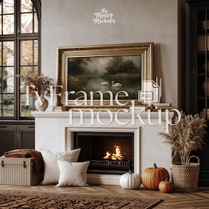 Puede incluir: Un acogedor salón con chimenea, obras de arte enmarcadas y calabazas decorativas. La obra de arte presenta un paisaje con cisnes. La chimenea tiene fuego. La habitación incluye almohadas, una cesta y un cofre de madera.