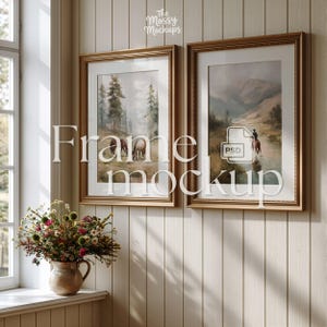 Op de afbeelding: Twee ingelijste kunstdrukken met goudkleurige frames hangen aan een lichtgekleurde wand met panelen. De kunst toont landschappen in gedempte kleuren. Een vaas met bloemen staat op een vensterbank. De tekst "Frame mockup" staat over de afbeelding.