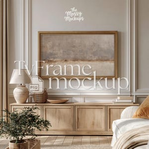 Puede incluir: Una escena de salón con un mueble de TV de madera y una pintura de paisaje enmarcada. Una lámpara, una cesta decorativa y una pequeña planta en una maceta tejida están sobre el mueble. El texto "TvFrame mockup" está superpuesto en la imagen.