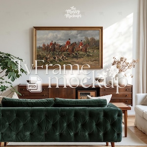 Op de afbeelding: Een ingelijst schilderij met een jachttafereel met ruiters te paard en honden. Het kunstwerk hangt boven een donkere houten kast. Een groene fluwelen bank en een witte vaas met gedroogde bloemen staan op de voorgrond.