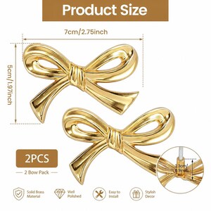 May include: Two gold-coloured bow-shaped decorative hardware pieces. Each bow measures approximately 7 cm wide and 5 cm high. The product is made of solid brass and is easy to install. The package includes two bows.