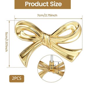 May include: A pair of gold-coloured bow-shaped cabinet pulls. Each pull measures 5 cm in height and 7 cm in width. The image includes the text "Product Size" and "2PCS".