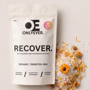 Könnte beinhalten: Ein weißer 500g Beutel Onlyever Recover Badezusatz mit schwarzem Text, der Recover, Elite Recovery Soak For Everyday Athletes, Organic, Targeted, Raw, Zechstein Magnesium, Eucalyptus/Peppermint und Calendula Flowers neben Salzkristallen anzeigt.