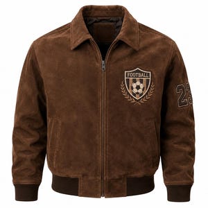 Puede incluir: Una chaqueta bomber de ante marrón con cremallera frontal completa, cuello clásico y puños y dobladillo acanalados. El pecho presenta un parche bordado con un balón y el texto FOOTBALL, mientras que el número 23 aparece en la manga.