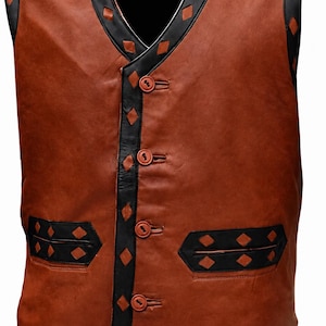 May include: A brown leather waistcoat featuring black leather trim along the V-neckline, armholes, and hem. The black trim is decorated with small diamond-shaped cutouts. The waistcoat closes with four brown buttons and includes two horizontal pockets.