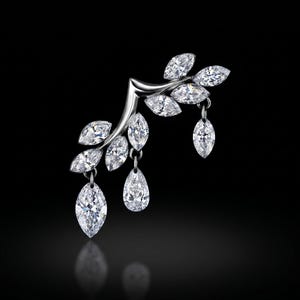 May include: A silver-toned ear cuff shaped like a branch with multiple marquise-cut clear stones set as leaves. Three additional marquise-cut stones hang from the branch as dangling charms, creating a delicate and reflective jewellery piece.