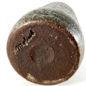 K&ouml;nnte beinhalten: Eine braune Keramikvase mit gr&uuml;ner Glasur. Der Boden der Vase ist mit dem Wort "Modula" gekennzeichnet.