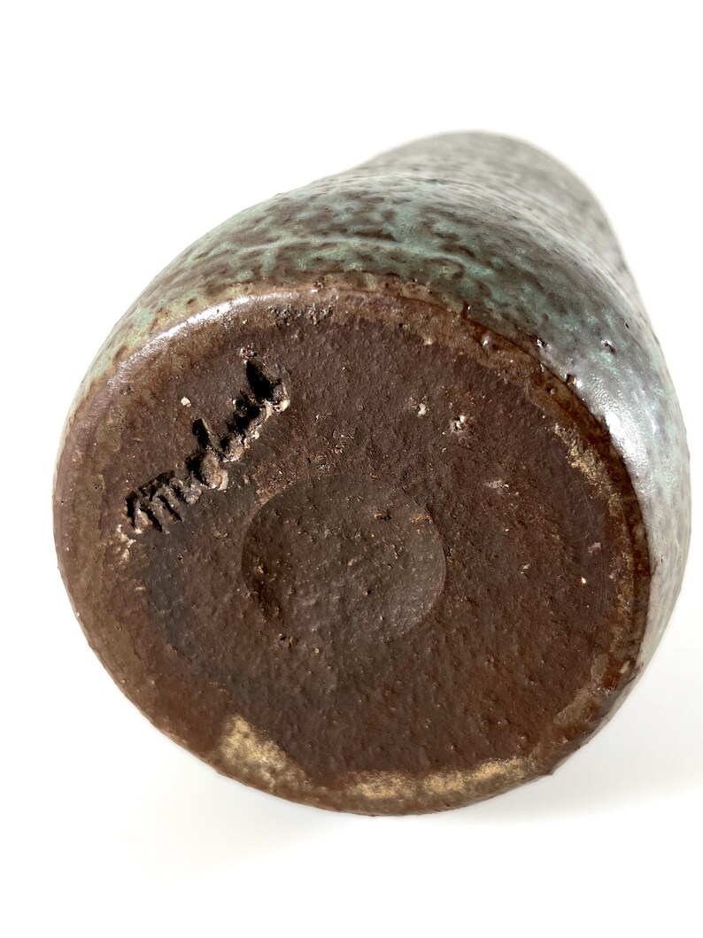 K&ouml;nnte beinhalten: Eine braune Keramikvase mit gr&uuml;ner Glasur. Der Boden der Vase ist mit dem Wort "Modula" gekennzeichnet.