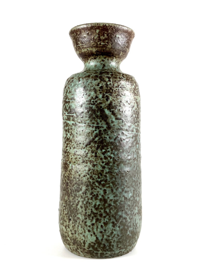 K&ouml;nnte beinhalten: Eine hohe Keramikvase mit einem gr&uuml;n-braunen, marmorierten &Uuml;berzug. Die Vase hat eine breite &Ouml;ffnung und einen schmalen Hals.