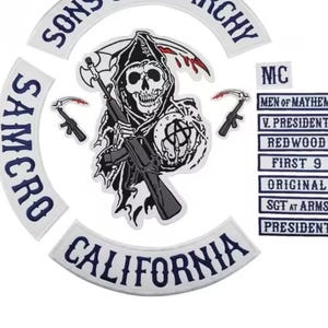 May include: A set of embroidered patches featuring a central grim reaper graphic holding a rifle and scythe, surrounded by curved text patches reading SONS OF ANARCHY, SAMCRO, and CALIFORNIA, plus rectangular patches with text including MC, MEN OF MAYHEM, V. PRESIDENT, REDWOOD, FIRST 9, ORIGINAL, SGT AT ARMS, and PRESIDENT.