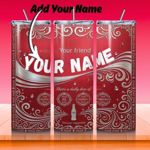 May include: Red and silver personalized tumbler with the text "YOUR NAME" in white. The tumbler features a Coca-Cola design with decorative swirls and the phrase "Share a daily dose of: Humor, Joy, Harmony, Happiness."