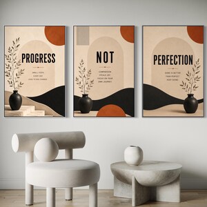 May include: Three rectangular wall art prints featuring beige backgrounds, black abstract shapes, and terracotta circles. Each print displays a black vase with a leafy branch and text: Progress, Not, and Perfection with motivational phrases.
