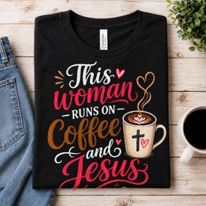 Puede incluir: Camiseta negra con el texto "This woman runs on coffee and Jesus". El dise&ntilde;o incluye una taza de caf&eacute; con una cruz y un coraz&oacute;n, y una escritura decorativa. La camiseta est&aacute; doblada sobre una superficie de madera.