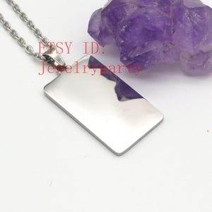Könnte beinhalten: Halskette mit rechteckigem, poliertem Silberanhänger. Der Anhänger ist ein glattes Rechteck mit abgerundeten Ecken, das an einer feinen Silberkette hängt. Der Text "ETSY ID: Jewelry art" ist rot. Im Hintergrund befindet sich ein violetter Kristall.