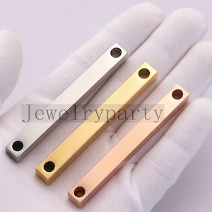 May include: Three metal bar pendants in silver, gold, and rose gold. Each pendant is rectangular with a hole at each end. The text "Jewelryparty" is visible on the image. These pendants are suitable for jewelry making.