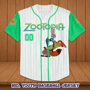 May include: White baseball jersey with green sleeves and accents. Features the word "Zootopia" in green and blue, along with a cartoon image of Judy Hopps and Nick Wilde. The number "00" is in green. The text "KID, YOUTH BASEBALL JERSEY" is at the bottom.