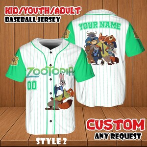 May include: White baseball jersey with green sleeves and accents, featuring the word "ZOOTOPIA" and the number "00". The jersey has a cartoon image of characters from the movie. The back of the jersey has the text "YOUR NAME" and a group of cartoon characters.
