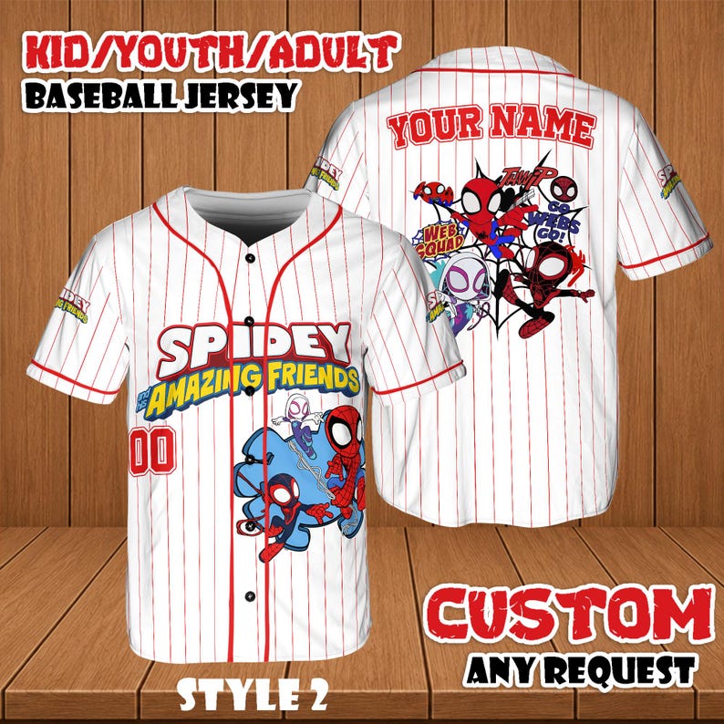 May include: White baseball jersey with red pinstripes and accents. The front features the text "SPIDEY AMAZING FRIENDS" and the number "00". The back has "YOUR NAME" and a graphic of Spider-Man characters. The jersey is labeled "STYLE 2".