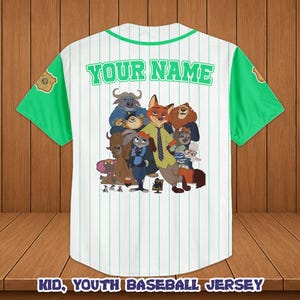 May include: White baseball jersey with green sleeves and collar, featuring a cartoon image of characters. The jersey has vertical stripes and the text "YOUR NAME" across the back. The bottom of the jersey reads "KID, YOUTH BASEBALL JERSEY".