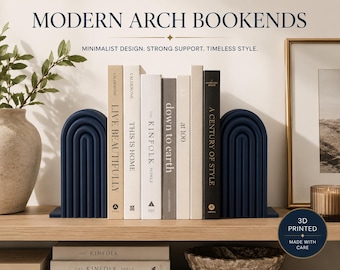 May include: Two dark navy blue arch-shaped bookends with a ribbed, tiered design. The bookends are positioned on a wooden shelf, holding a row of six books with various neutral-colored spines. Text on the image reads MODERN ARCH BOOKENDS.