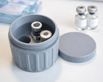 May include: A grey cylindrical medication storage and transport container with a removable lid, featuring internal slots for vials. The text reads: MEDICATION STORAGE & TRANSPORT CONTAINER. Perfect for hormones, insulin, peptides, and more.