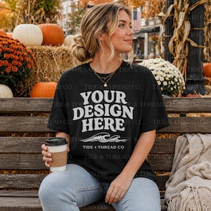 Peut inclure: Un t-shirt noir à manches courtes avec le texte blanc YOUR DESIGN HERE, un motif de vagues océaniques en dessous et le texte TIDE + THREAD CO sous les vagues. Le t-shirt possède une encolure ronde et est en tissu noir uni.