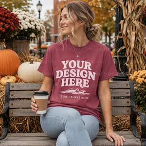 May include: A maroon short-sleeve t-shirt featuring the white text YOUR DESIGN HERE above a graphic of two ocean waves and the text TIDE + THREAD CO. The shirt is worn with light blue denim jeans and paired with a disposable coffee cup.