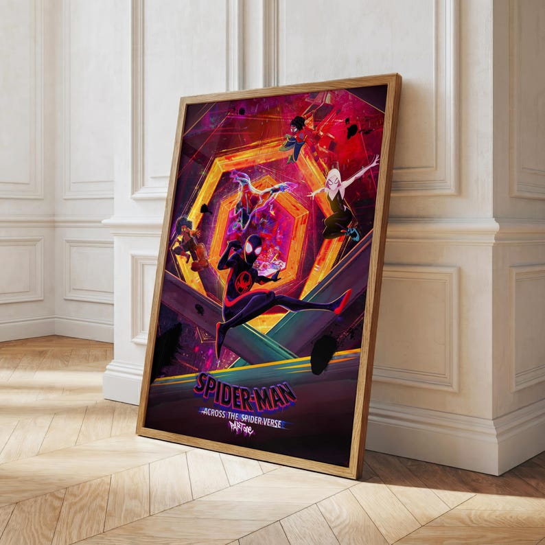 Puede incluir: P&oacute;ster enmarcado con personajes de Spider-Man en una escena din&aacute;mica. La obra de arte utiliza colores vibrantes, con un enfoque en los personajes en un entorno futurista. El p&oacute;ster est&aacute; en un marco de madera, apoyado contra una pared blanca.