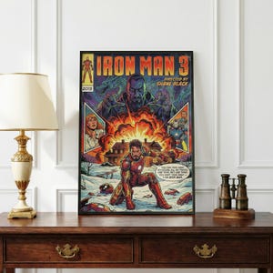 Pode incluir: P&ocirc;ster de Iron Man 3 emoldurado. A ilustra&ccedil;&atilde;o em estilo de quadrinhos mostra o Homem de Ferro em sua roupa, explos&otilde;es e outros personagens. O texto inclui "Iron Man 3" e "Directed by Shane Black."