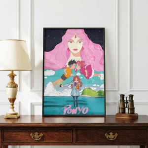 May include: A framed art print featuring the word "Ponyo" at the bottom. The artwork depicts a large pink-haired figure above two floating figures kissing. A girl in a striped outfit stands in front of the ocean.