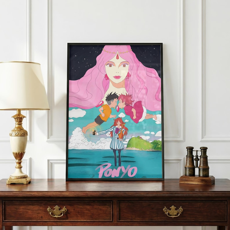 May include: A framed art print featuring the word "Ponyo" at the bottom. The artwork depicts a large pink-haired figure above two floating figures kissing. A girl in a striped outfit stands in front of the ocean.