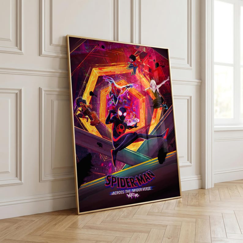 Puede incluir: P&oacute;ster enmarcado con personajes de Spider-Man de la pel&iacute;cula "Across the Spider-Verse". La obra de arte utiliza colores vibrantes, incluyendo rojo, morado y naranja. El p&oacute;ster se muestra contra una pared blanca y un suelo de madera.